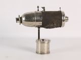 an old silver object on a white surface with a white background