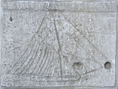 une plaque en pierre sur laquelle est sculpté un bateau