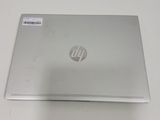 the back of a silver laptop sitting on top of a white table