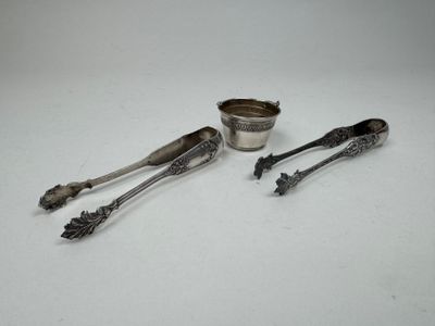 two silver spoons and a silver cup on a white surface