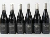 six bouteilles de vin rouge sont alignées sur une table