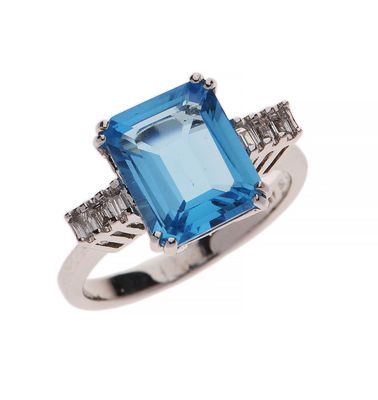 gros plan d'une bague avec une pierre bleue et des diamants