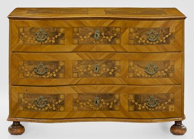 une commode en bois dont les tiroirs sont ornés de sculptures élaborées