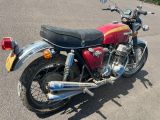 une moto rouge garée sur le bord de la route