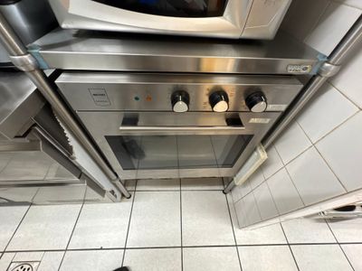 un micro-ondes posé sur une cuisinière dans une cuisine