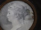portrait of a woman in profile in a black and gold frame