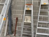 trois échelles appuyées contre un mur