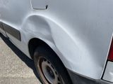 the rear end of a van with a flat tire on a parking lot