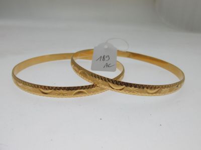 deux bracelets en or ornés de motifs gravés sur un fond blanc