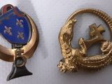 deux insignes représentant une croix et un bouclier, sur fond blanc