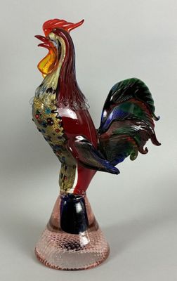 a colorful rooster statue on a stand on a white background