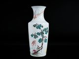 a white vase with a bird and flowers on it