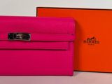 un portefeuille Hermeson rose et orange à côté d'une boîte orange
