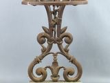 an antique cast iron table with a green marble top