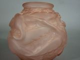 a pink glass vase with a swirly design on it