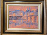 une peinture à l'huile représentant un paysage urbain, dans un cadre doré, accrochée au mur
