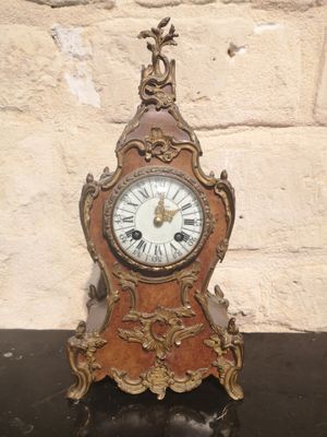 a clock that is sitting on a table in front of a brick wall
