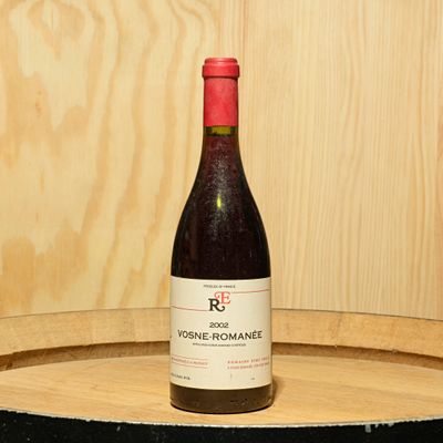 a bottle of wine sitting on top of a barrel