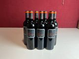 six bouteilles de vin rouge sont alignées sur une table