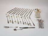 many forks and spoons laid out on the table