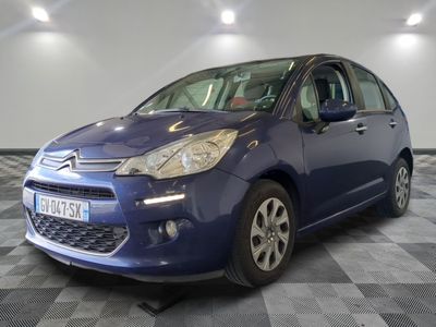 la petite voiture bleue est garée sur un carrelage à carreaux