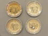 quatre assiettes ornées de photos de personnes, posées sur une table