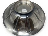 a metal bowl on a white surface with a label on it