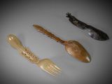 three wooden spoons and a fork sitting on a table