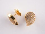 gros plan d'une paire de boucles d'oreilles sur une surface blanche