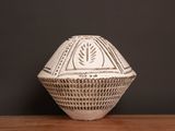 a white vase sitting on top of a wooden table