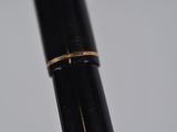 the tip of a fountain pen with a gold band on it