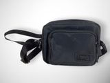 a black cross body bag sitting on top of a white table