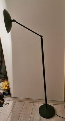 a black floor lamp that is on a wooden floor