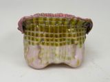 a pink and green vase sitting on a white surface