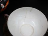 a white bowl and a black cup on a table