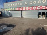 un homme qui fait du skateboard dans la rue, devant un magasin