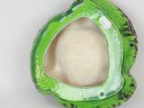 a close up of a green vase with a hole in it
