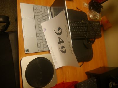 un ordinateur portable posé sur un bureau, à côté d'un haut-parleur