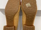 a pair of women ' s wedged sandals with a woven sole