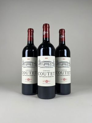 three bottles of red wine sitting next to each other on a table