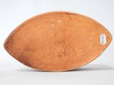 an old wooden bowl with a tag on it sitting on a white surface