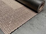 un gros plan sur un tapis sur lequel est posé un rouleau de tissu