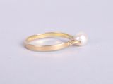 a gold ring with a pearl on the side