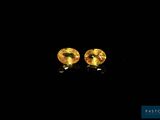 une paire de boucles d'oreilles en saphir jaune sur fond noir