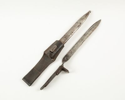 Deux vieux couteaux sont posés l'un à côté de l'autre sur une surface blanche.