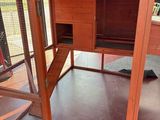 the inside of a chicken coop with a door open