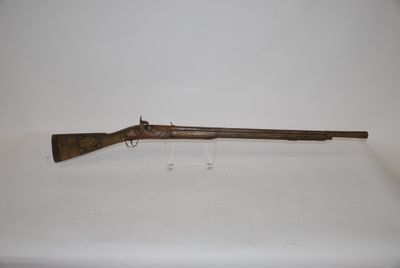 an old rifle with a wooden barrel on a white surface