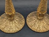 pair of gold plated candlesticks with leaves on them