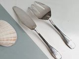 two forks and a knife on a table next to a shell