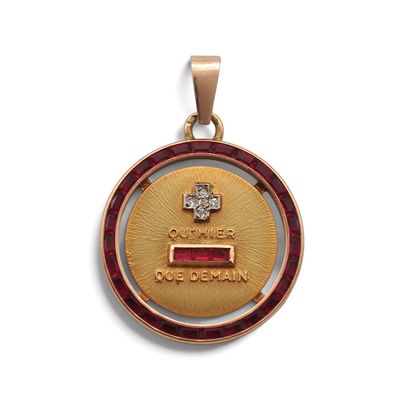 un gros plan d'une médaille d'or ornée d'une pierre rouge en son centre